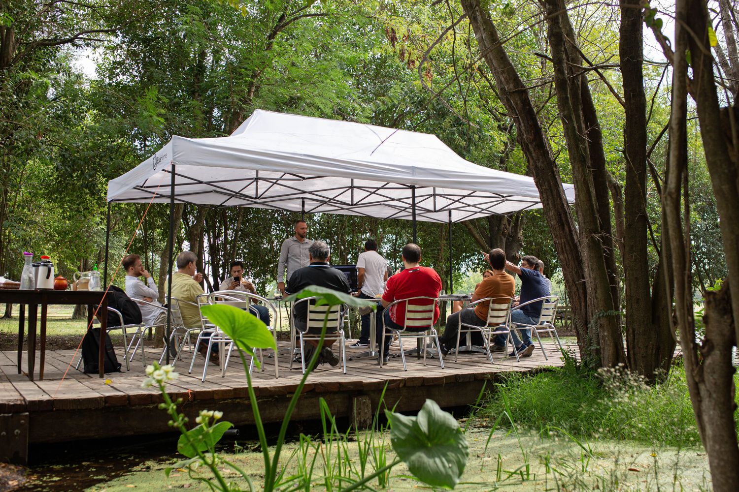 Reunión de trabajo bajo un gazebo junto a la laguna